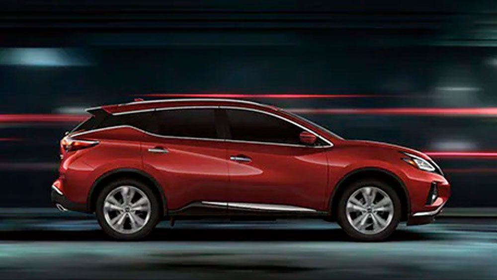 2023 Nissan Murano shown in profile driving down a street at night illustrating performance. | Destination Nissan in Albany NY